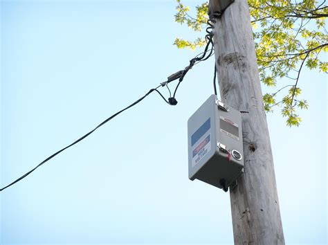 black mesh box on electric poles|town's utility pole boxes.